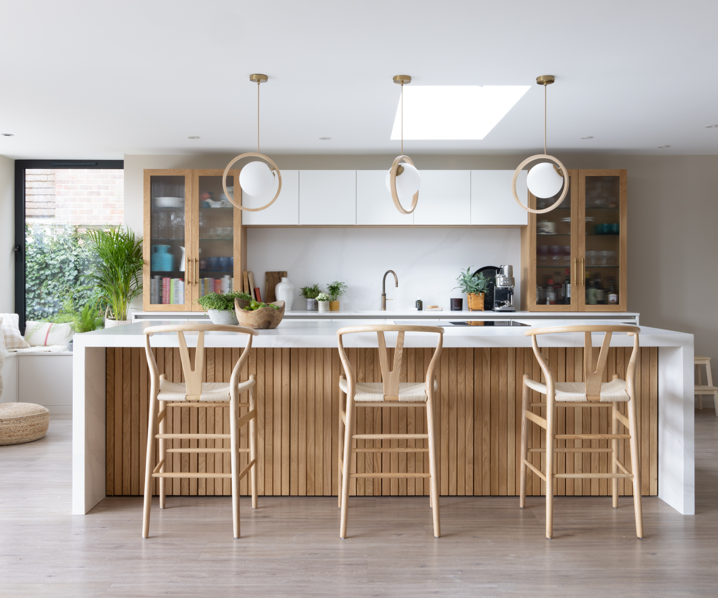 wood and white kitchen with three wood and white spherical pendant above kitchen island