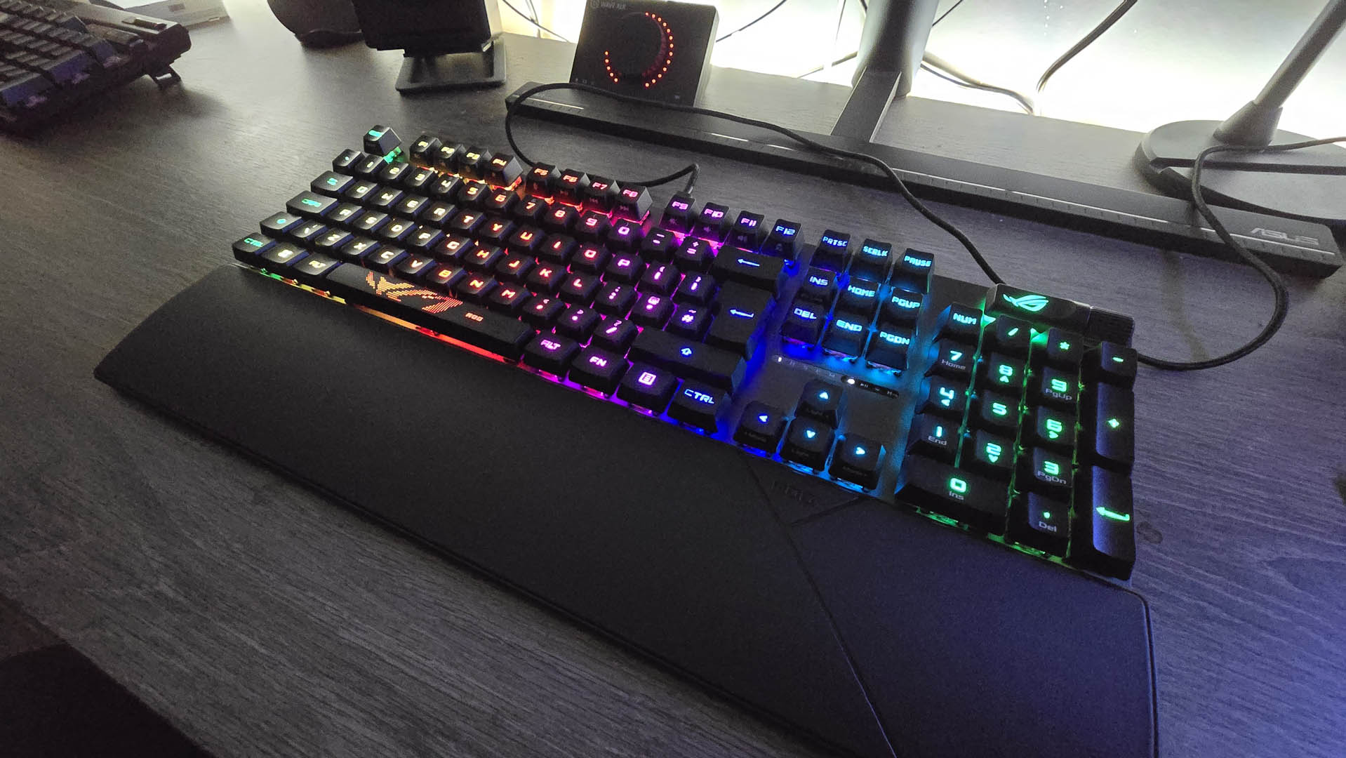 The Asus ROG Strix II RX gaming keyboard photographed on a wooden desk.