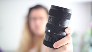 Photographer holding the Sigma 17-40mm f/1.8 DC | A lens towards the camera
