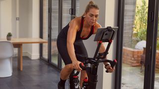 Woman cycles indoors on the Wattbike Atom