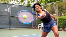Woman hitting tennis ball on tennis court