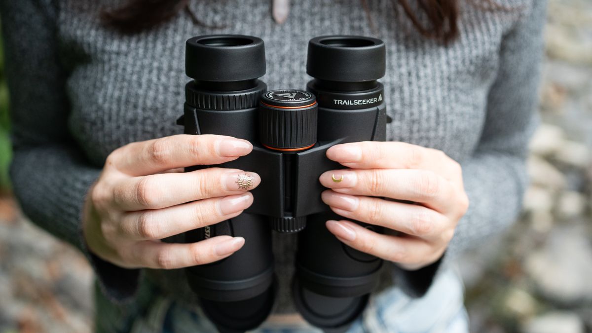 woman using the Celestron TrailSeeker 10x42 by a river