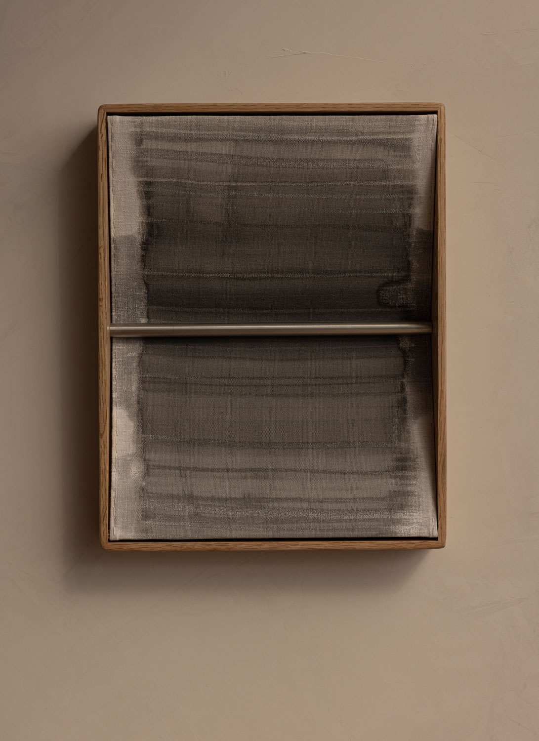 Framed abstract artwork at 262 Fifth Avenue, featuring layered dark brushstrokes on a textured surface within a simple timber frame.