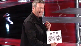 Blake Shelton holds a drawing of himself and a duo on The Voice.