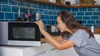 Woman using a cleaning hack for microwave