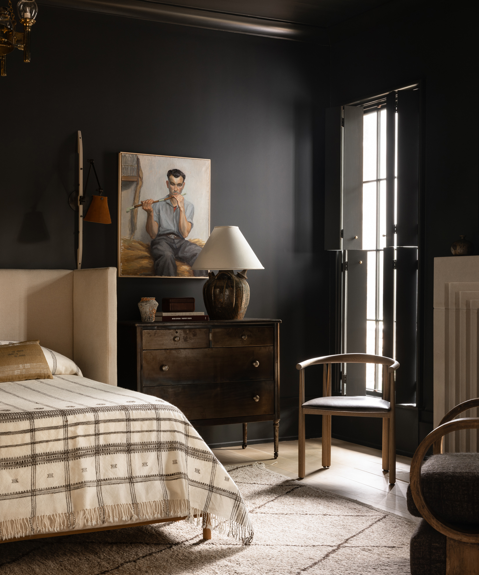 bedroom with black walls and pale bed and rug