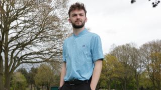 A golfer stands whilst wearing the Adidas Ultimate365 Allover Print Polo Shirt 