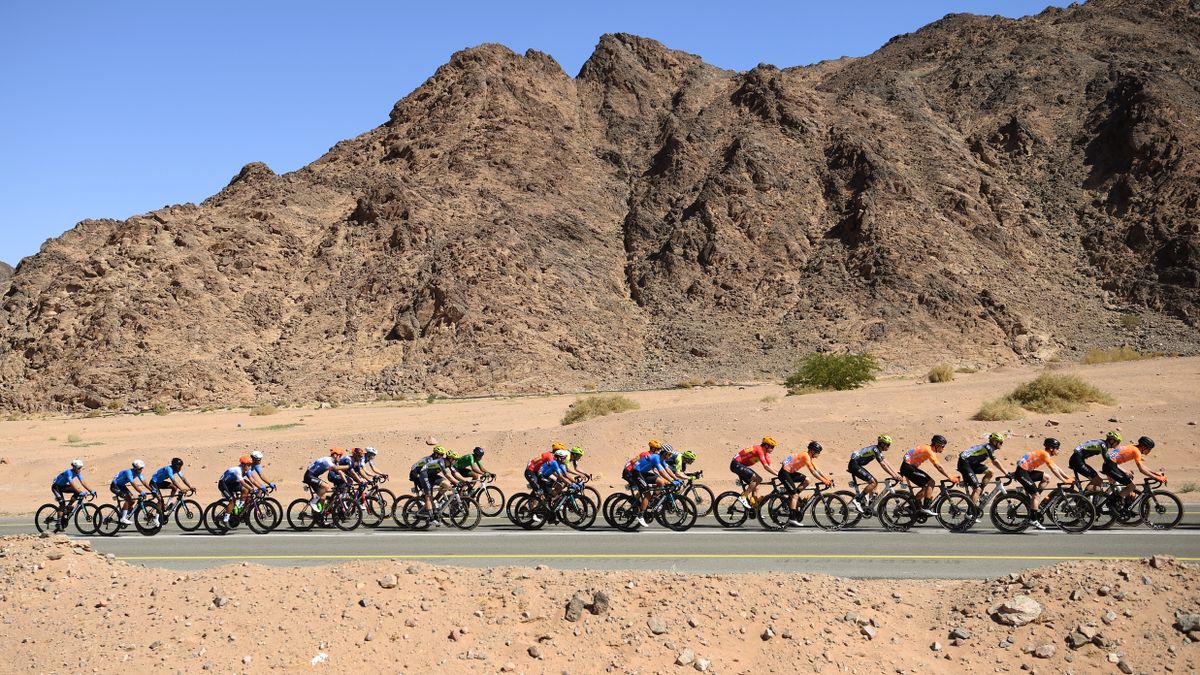 A side-view of the peloton riding through the Saudi Arabian desert during the 2025 AlUla Tour