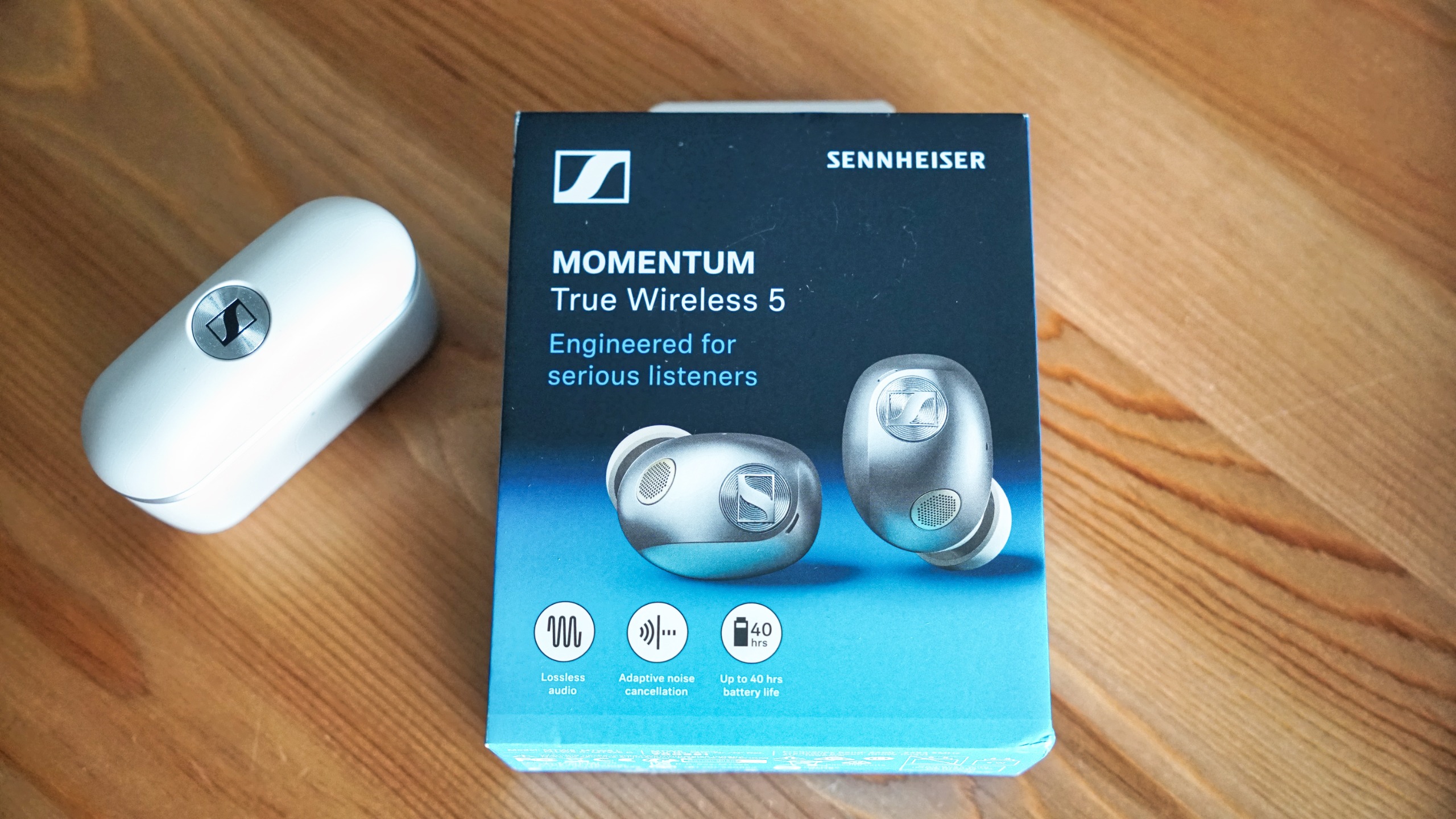 Sennheiser Momentum True Wireless 5 in white, showing details of the buds held in a hand