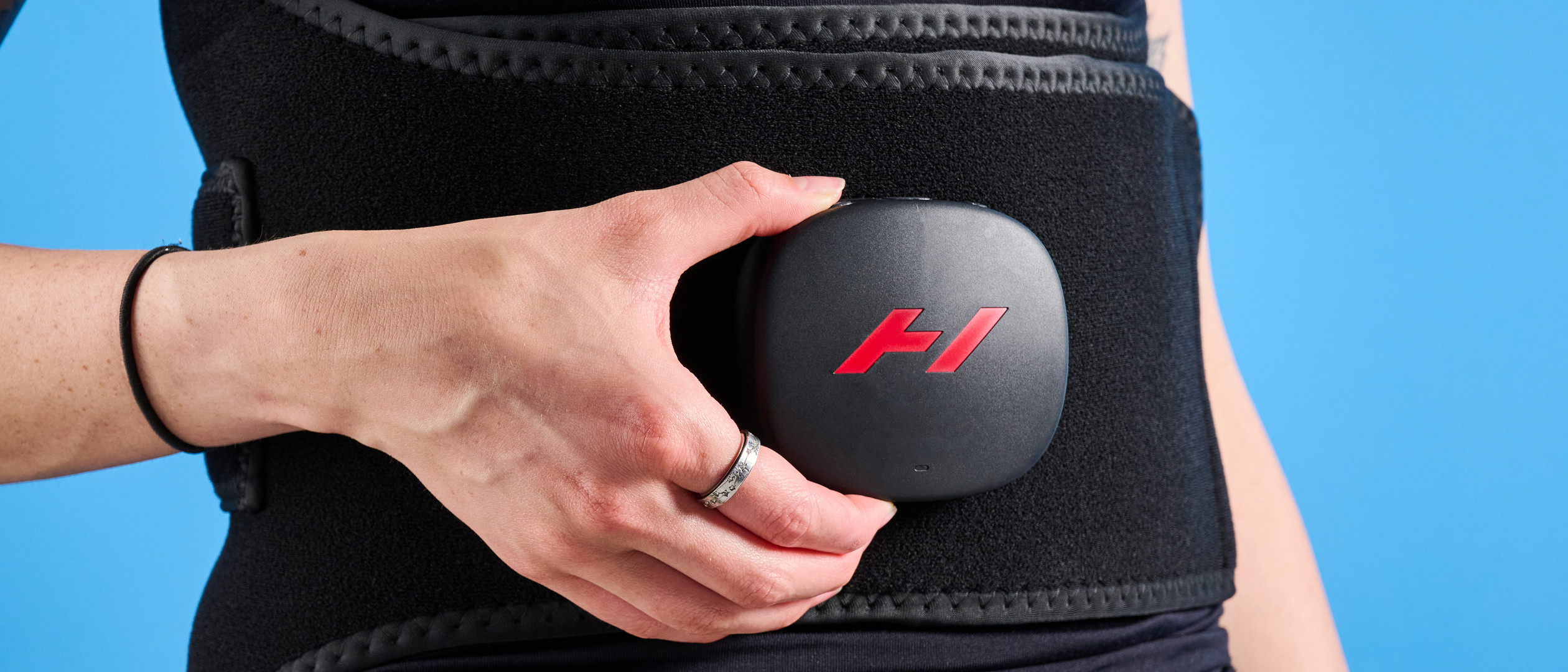 Hyperice Venom 2 Back being worn by a woman photographed in front of a ble background