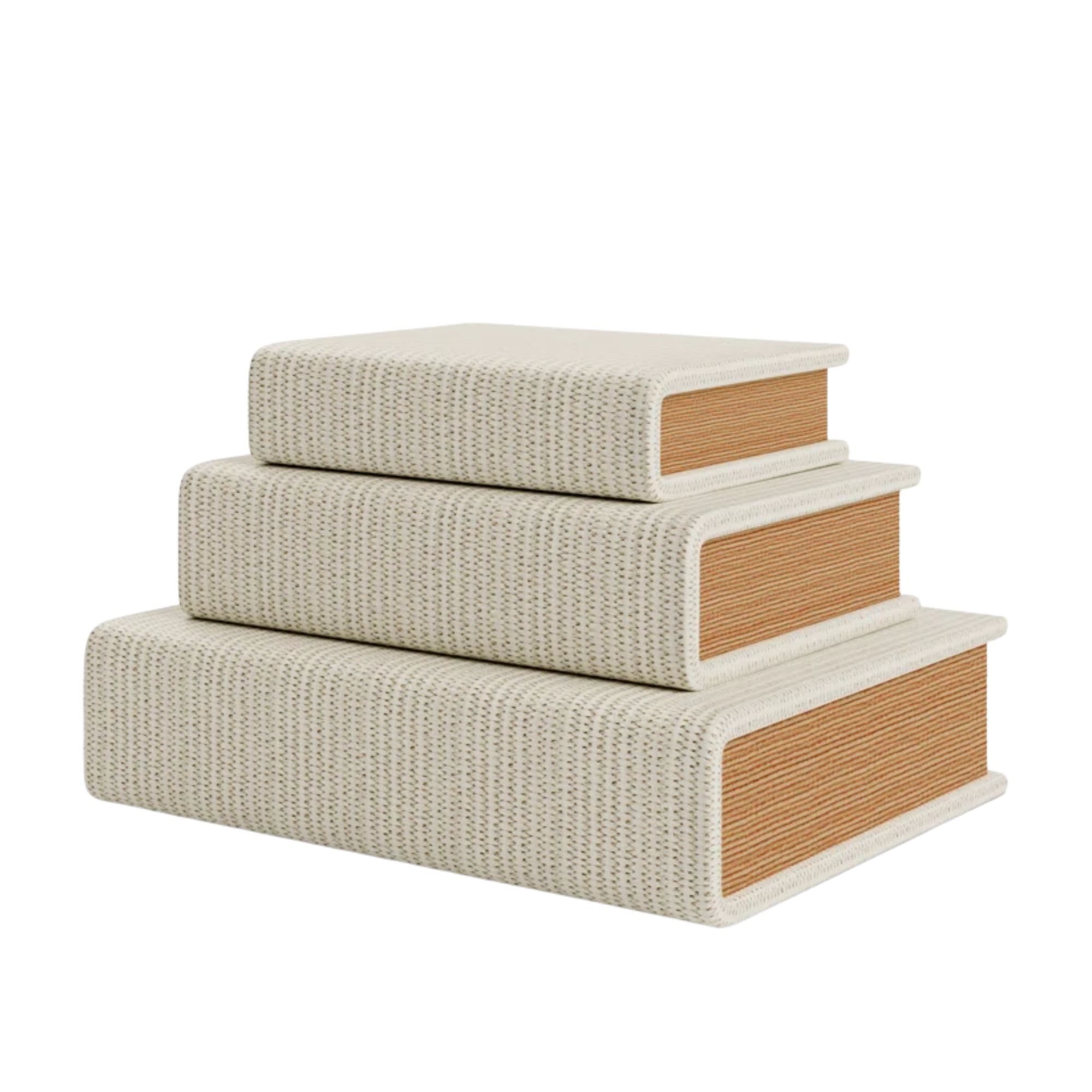 A stack of three white woven book-shaped storage boxes