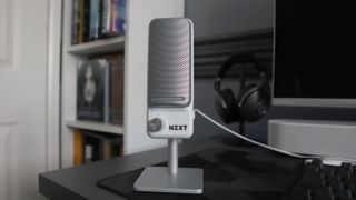 An NZXT Capsule Elite microphone set up on a desk with lighting enabled.