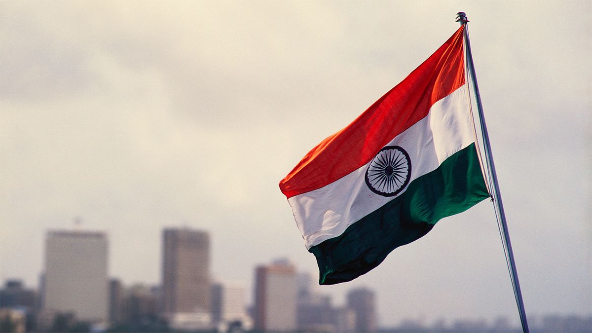 Indian flag flying, with city skyline in background