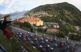 A spectator snaps a photo of the Giro di Lombardia peloton.