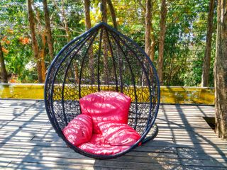 hanging chair with colourful cushion on a decked area