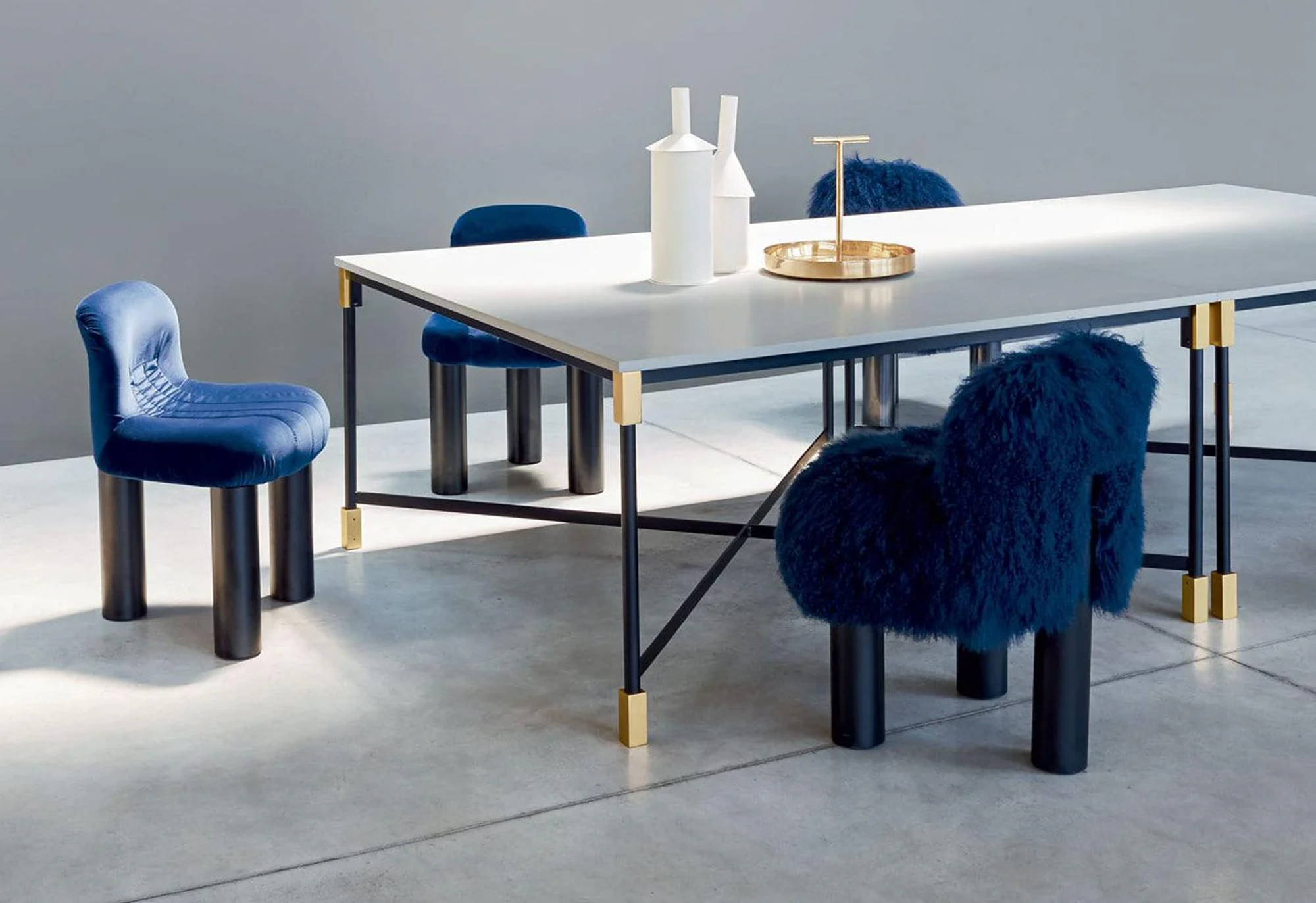 a dining table surrounded by blue chairs, including a furry blue accent chair