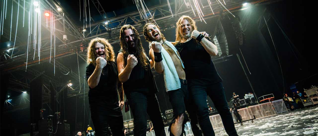 Airbourne standing in an empty arena holding their first aloft