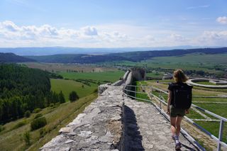 Image shows Anna walking along the walls of Spiš Castle in Slovakia
