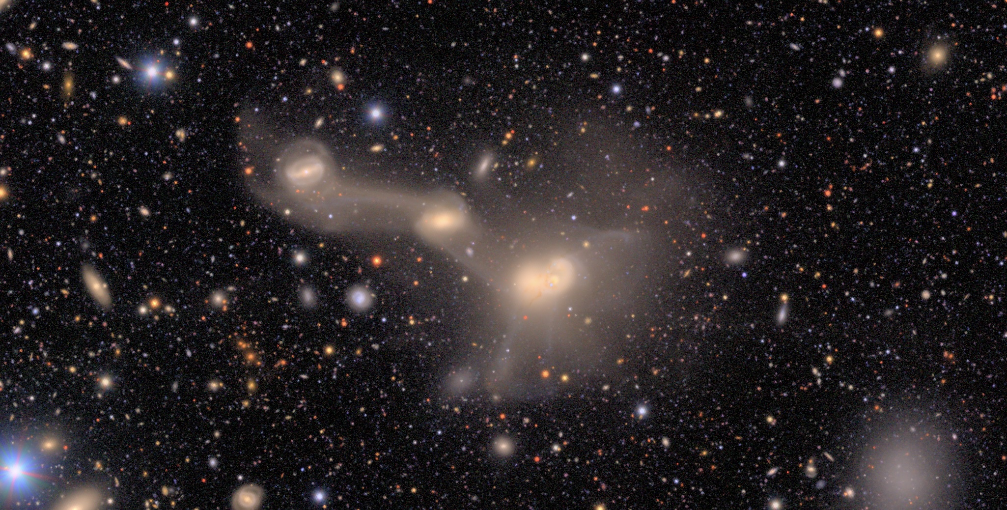 an image of three galaxies connected by wispy clouds