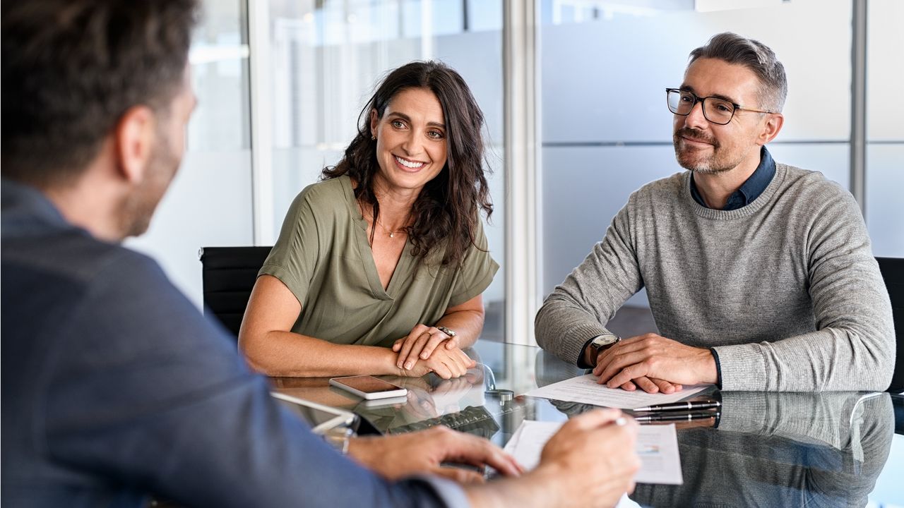 A couple do retirement planning with life insurance with a financial adviser.