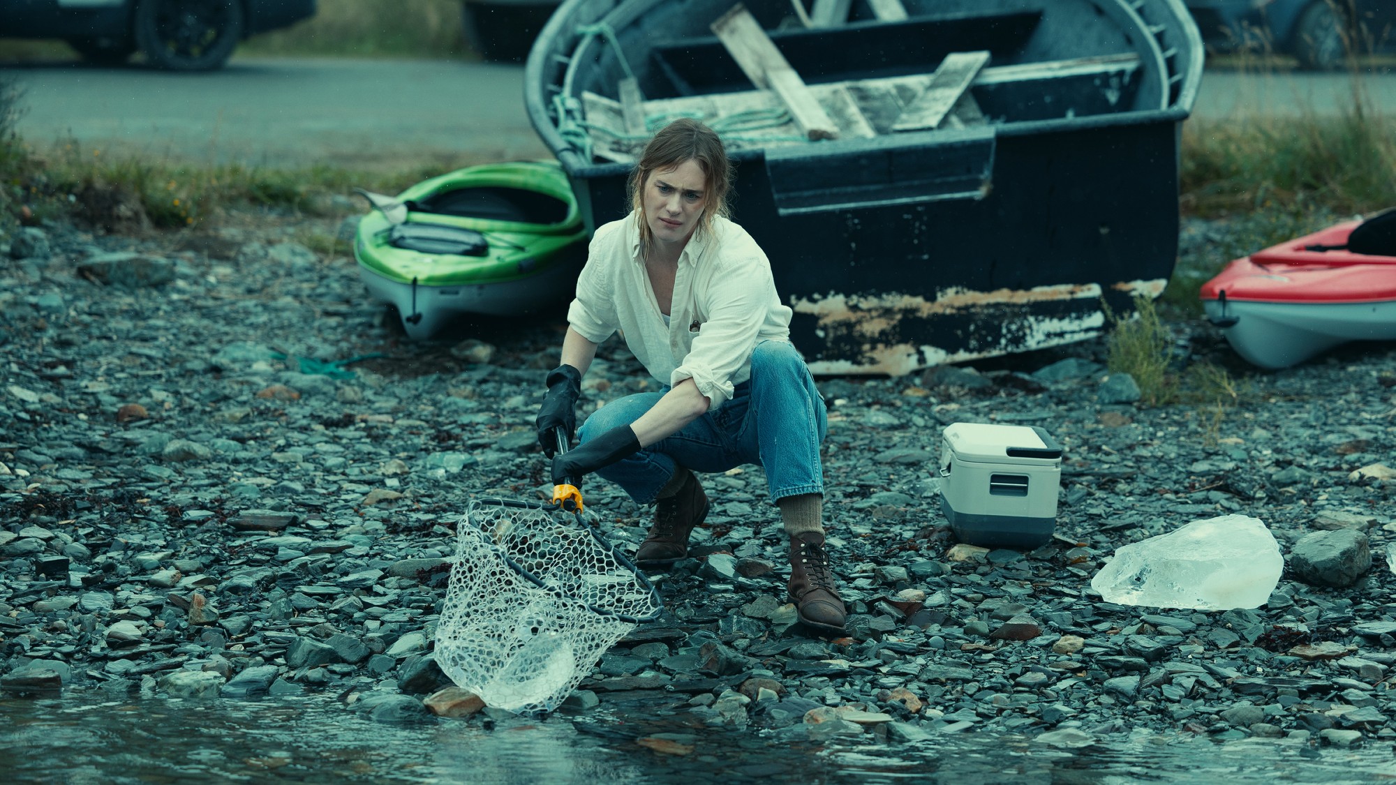 Dr. Howander trying to collect chunks of ice from the water.