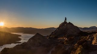A hiker atop Ben A'an at sunset