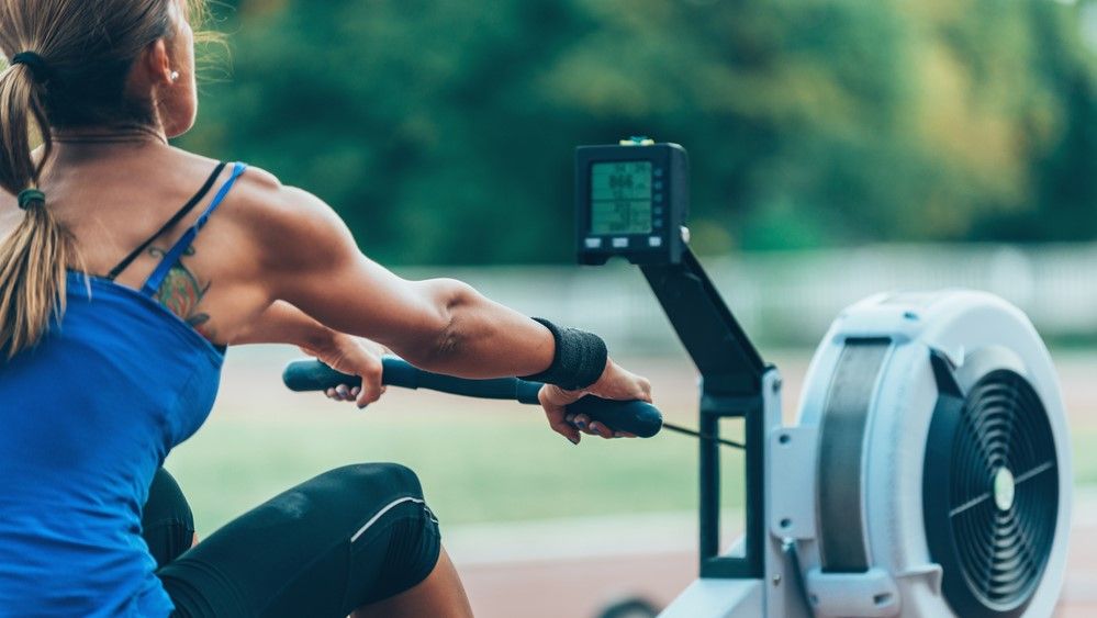 a photo of a woman rowing on a rowing machine 