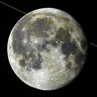 A photo of the full moon, with a time-lapse of Saturn passing by in a diagonal line in the background