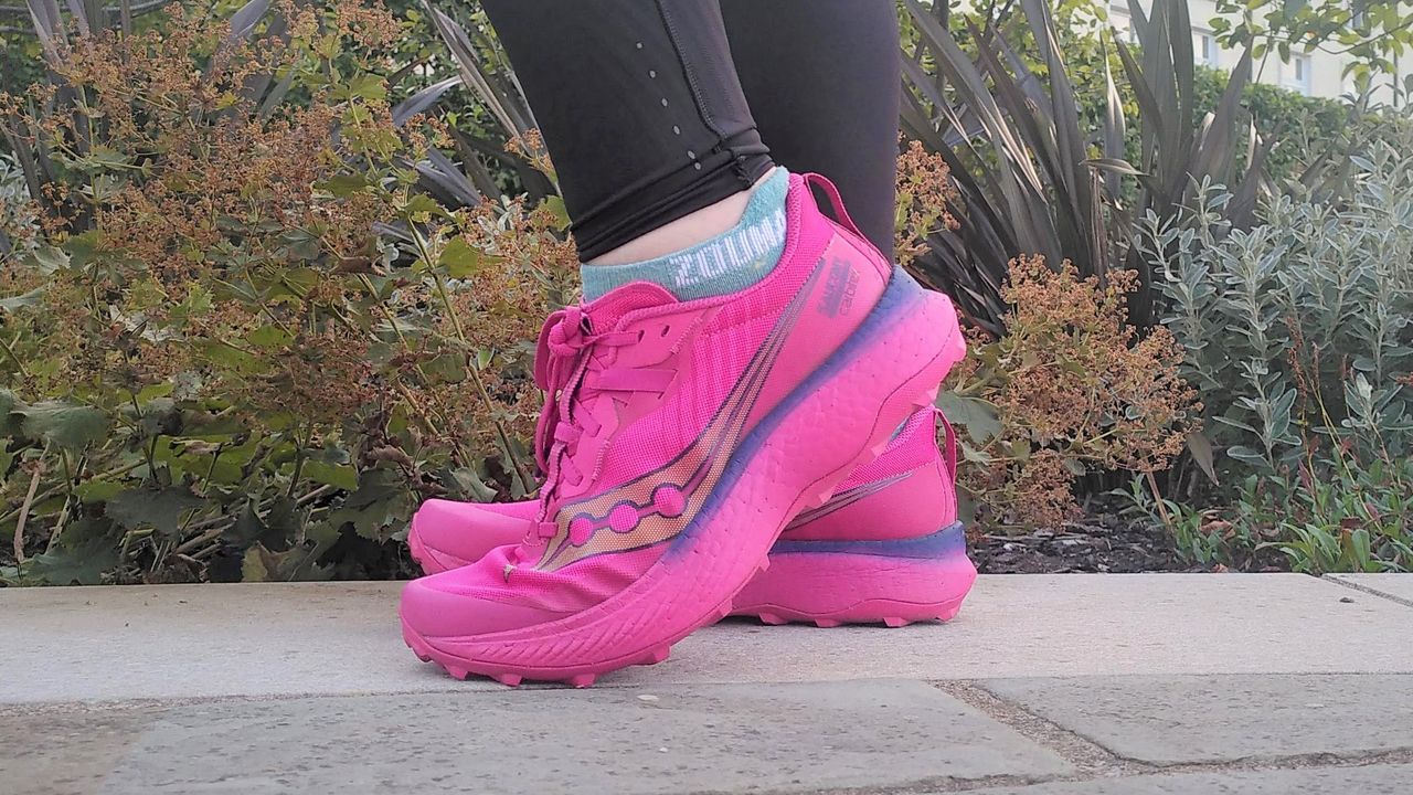 A runner's feet wearing bright pink Saucony Endorphin Edge shoes