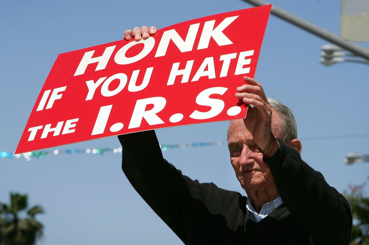 A man holds a sign that reads &amp;quot;Honk if you hate the I.R.S.&amp;quot;