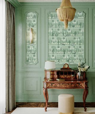 Regencycore inspired space with sage green painted wall panels, and coordinating patterned wallpaper.
