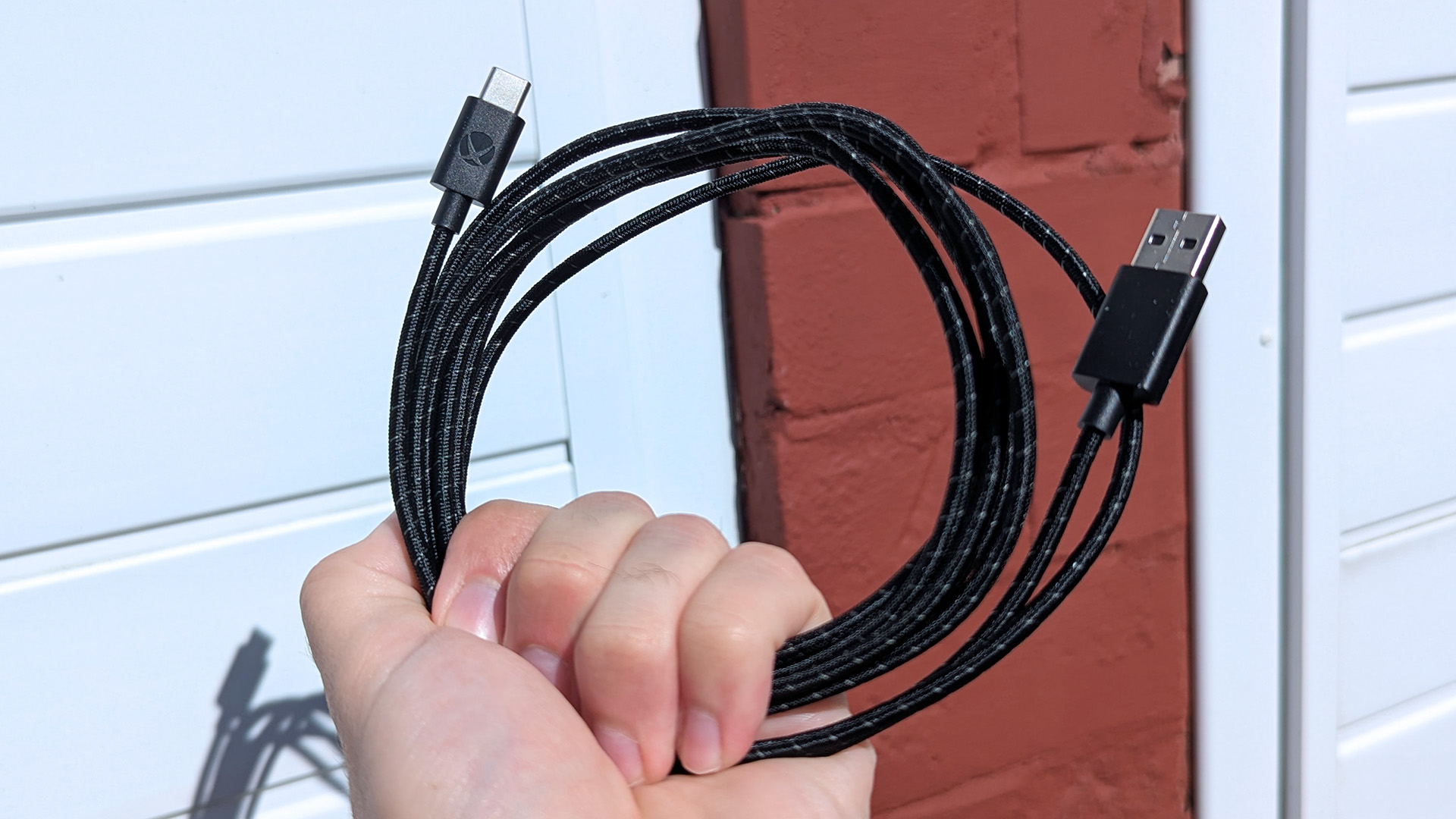 Braided black USB-C cable held in hand, showing Xbox logo, designed for Xbox Adaptive Joystick