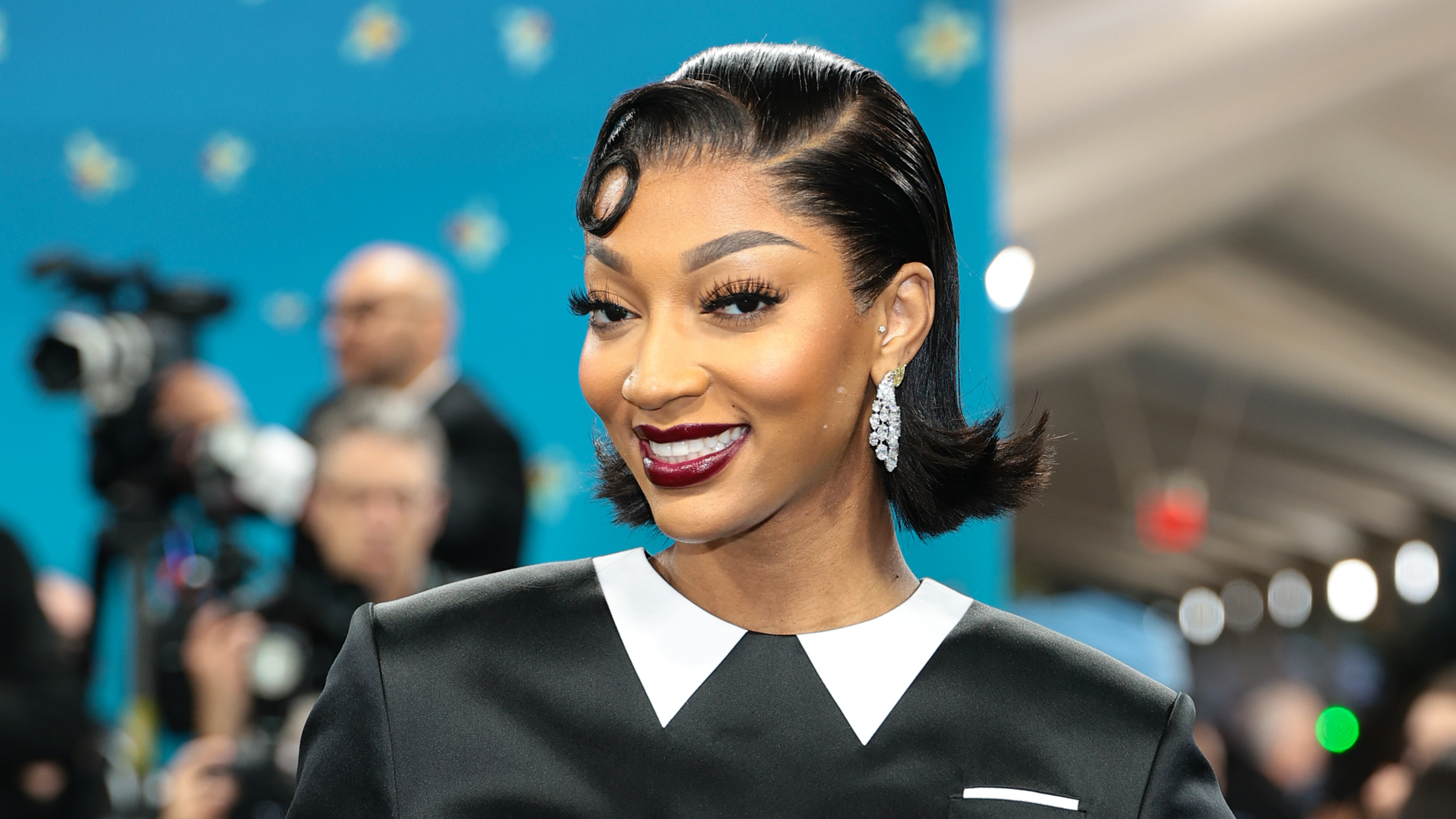 Angel Reese wearing a kiss curl hairstyle and a bold lip color.