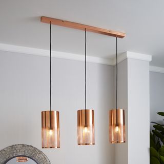 there hanging copper glass vessel pendant lights over a kitchen island