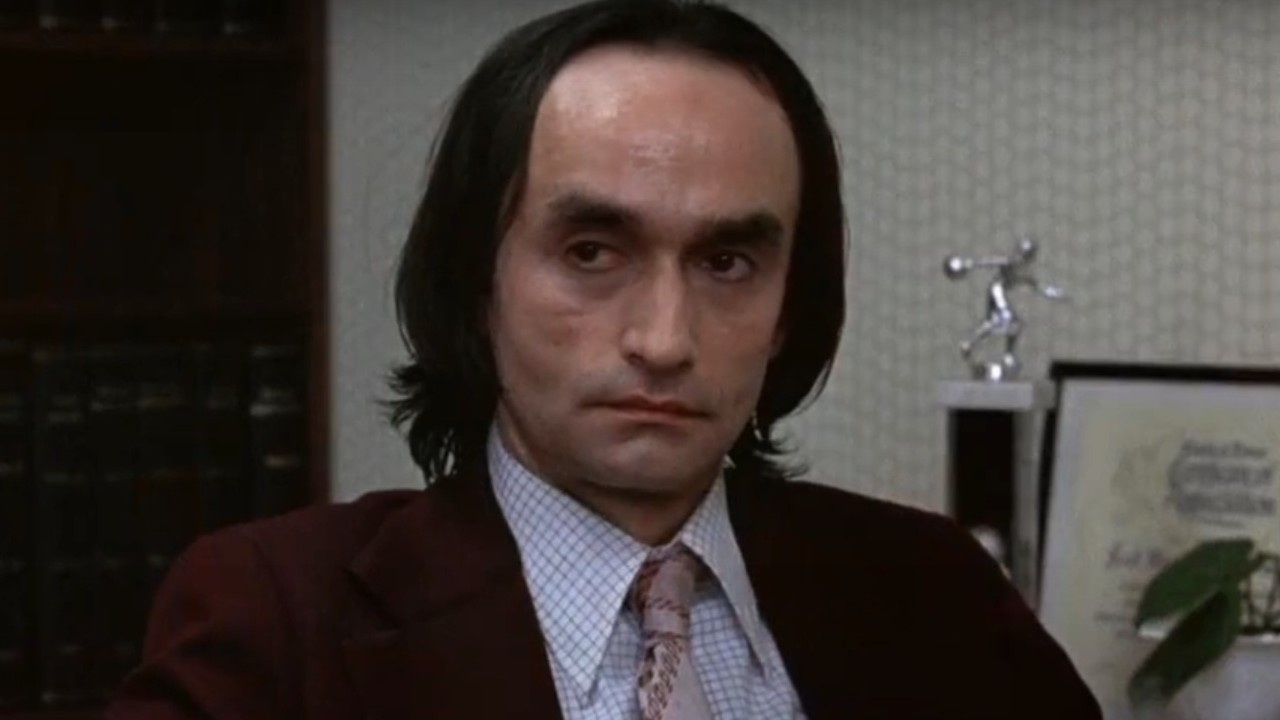 John Cazale sitting in an office in Dog Day Afternoon