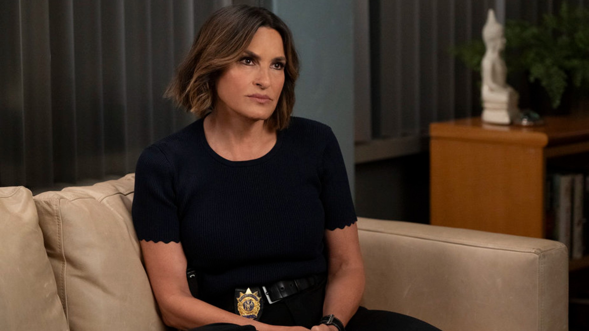 Benson sitting on a couch on Law &amp; Order: SVU.