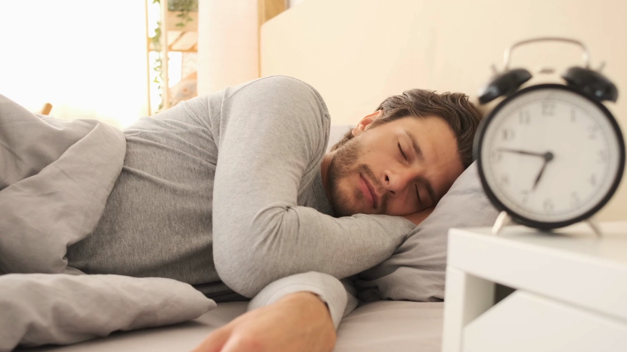 man sleeping with alarm clock