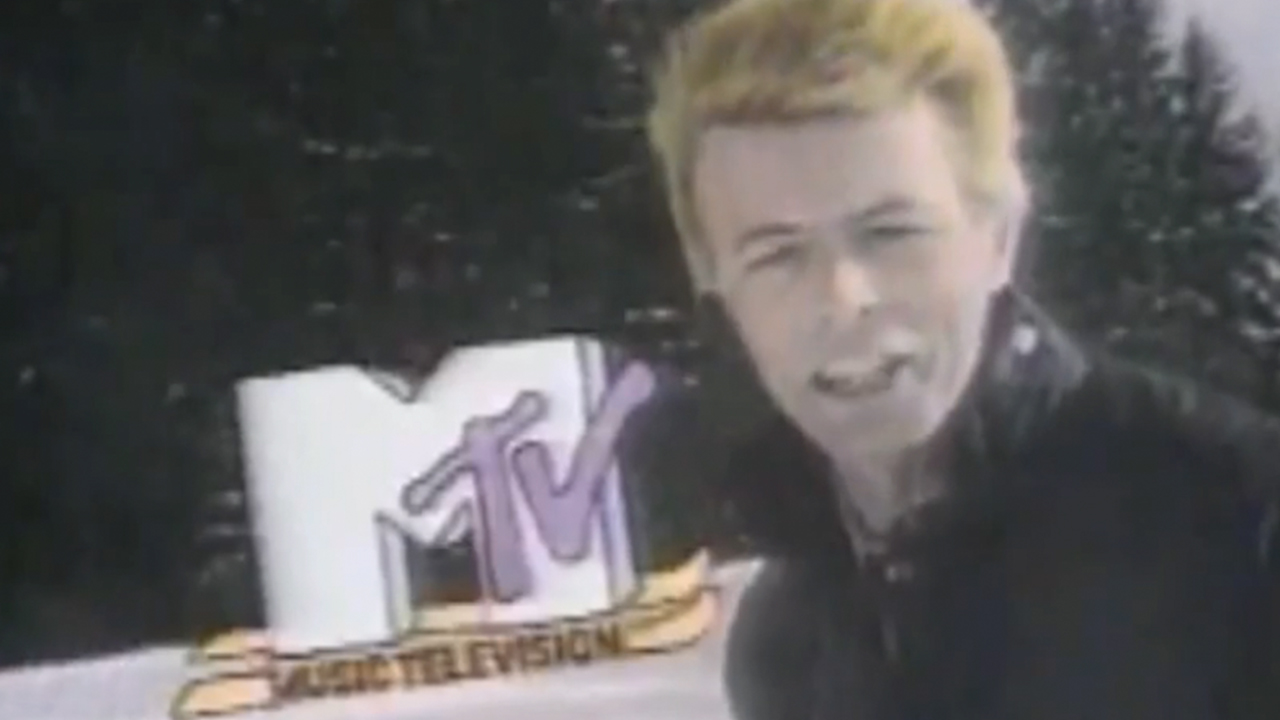 David Bowie on a ski slope with the MTV logo behind him