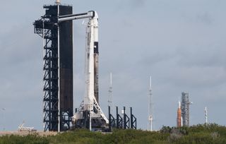 NASA's Space Launch System rocket with the Orion spacecraft aboard is seen at right atop a mobile launcher on April 6 at Kennedy Space Center's Launch Complex 39B as the Artemis 1 launch team prepares for the next attempt of the wet dress rehearsal test. At left, a SpaceX Falcon 9 rocket with the company's Crew Dragon spacecraft aboard is seen on the launch pad at KSC's Launch Complex 39A as preparations continue for the planned April 8 launch of the Ax-1 mission to the International Space Station.