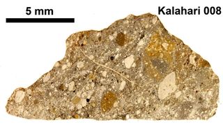 Pictured here is the moon meteorite Kalahari 008. Meteorite impacts on the moon can eject lunar material that then falls to Earth as a lunar meteorite. Kalahari 008 is a 600-gram lunar meteorite collected in 1999 in Botswana's Kalahari Desert.