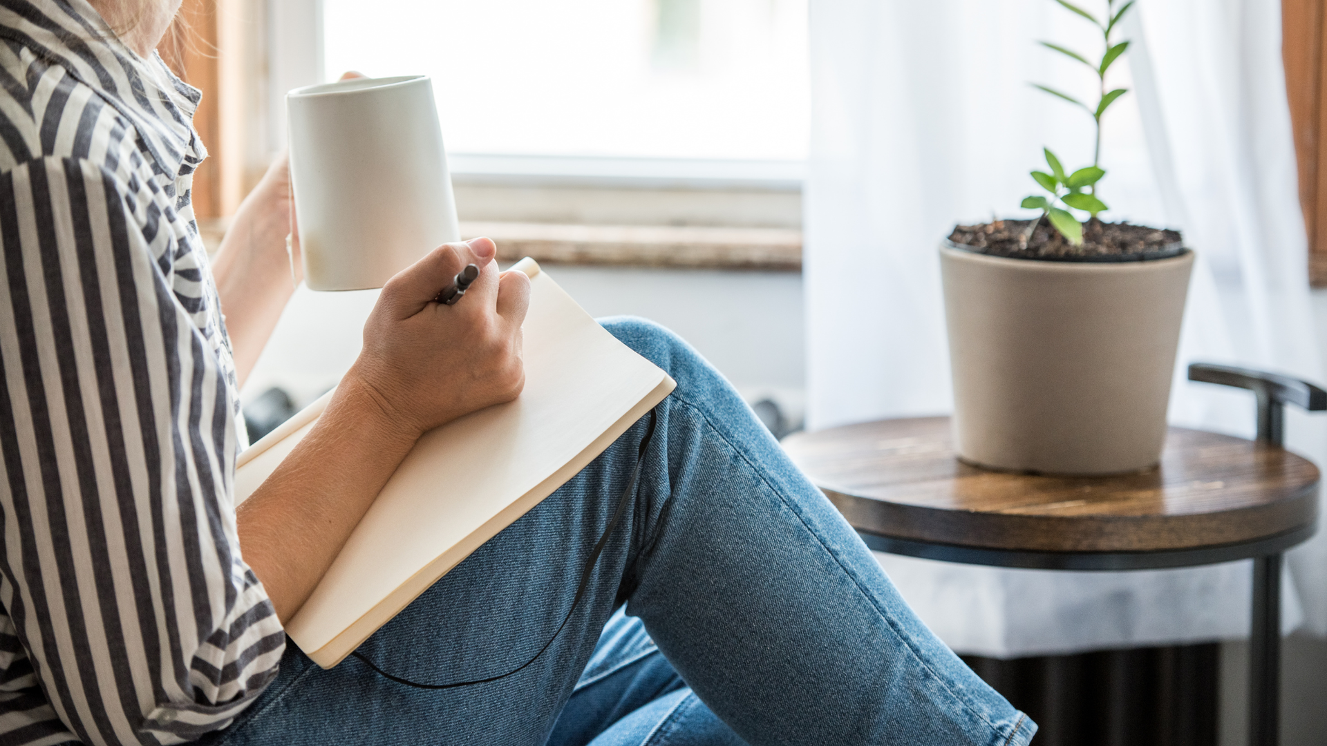 A woman sat writing in a notepad working out what to do when your ex texts you