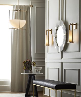 A hallway lighting idea with matching contemporary gold ceiling pendant and sconces from Arteriors