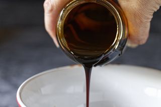 Jar of molasses being poured into a bowl