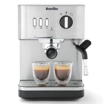 Brevill Espresso Coffee Machine on a white counter-top next to a croissant and a coffee-filled jar