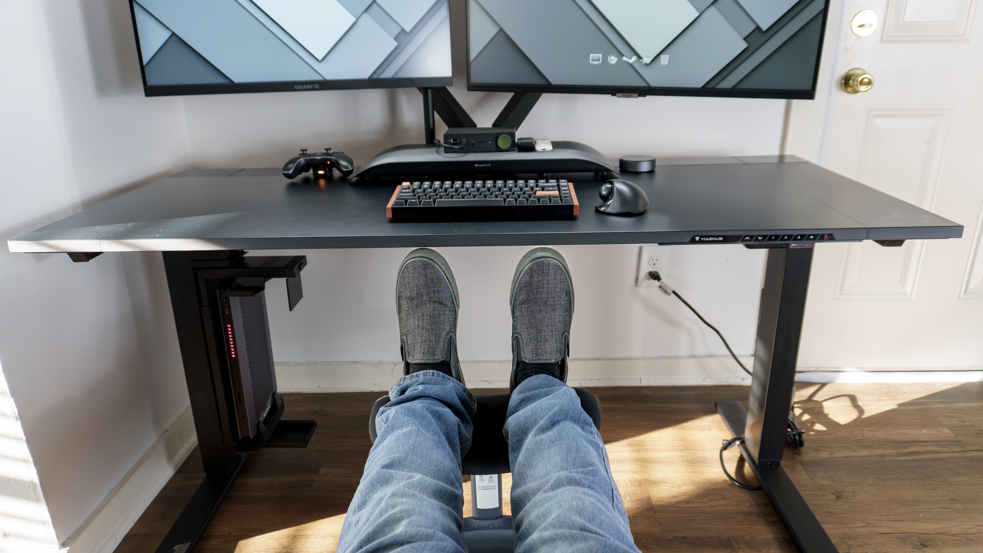 A person reclining on the LiberNovo Omni office chair with their feet up on the LiberNovo StepSync footrest