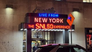 The outside neon sign that says: "Live from New York, The SNL 50 Experience."