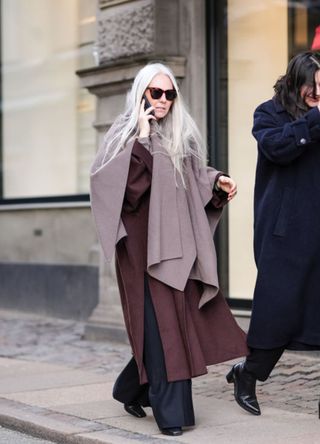 A woman wearing an oversized scarf with a burgundy coat