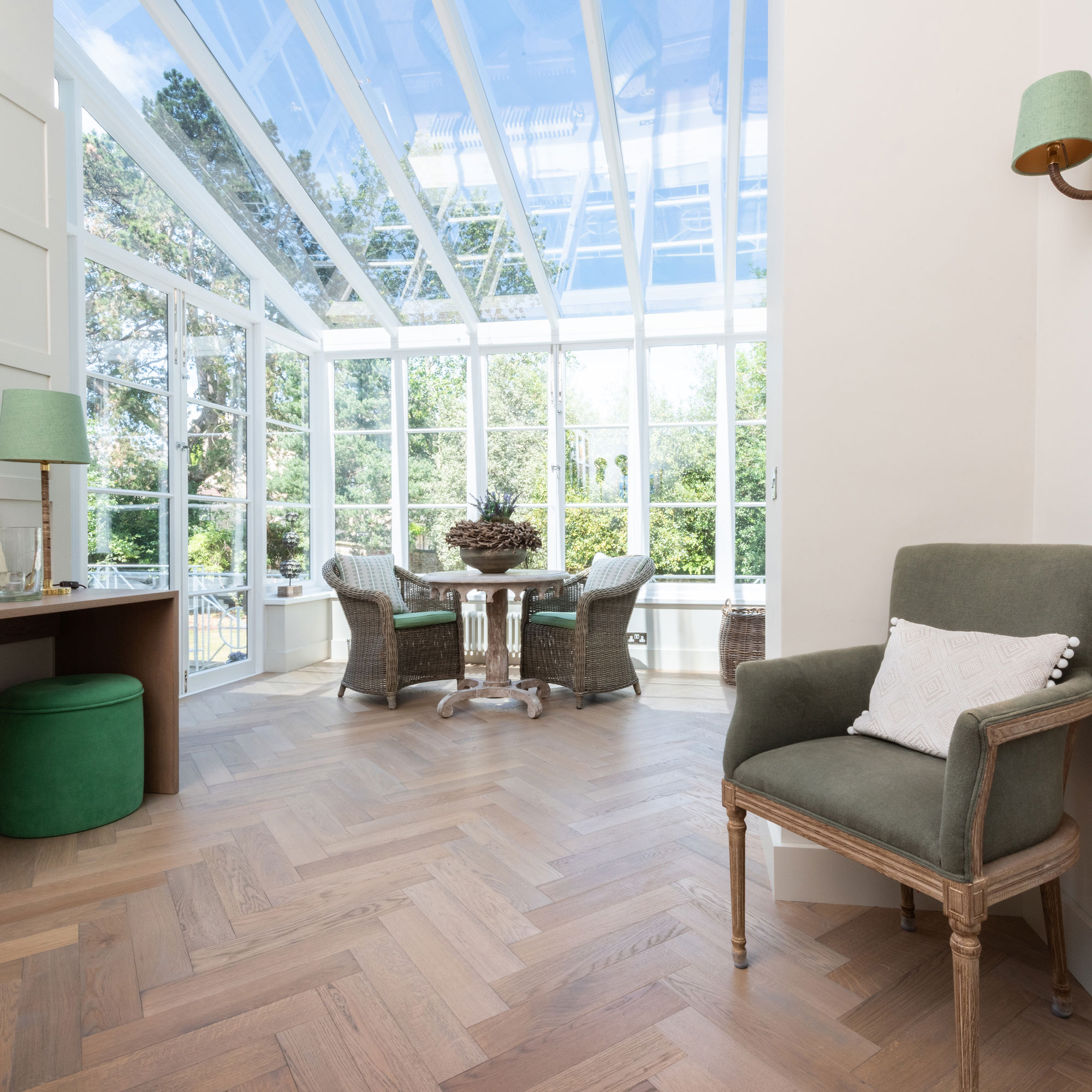 large conservatory with herringbone wood flooring