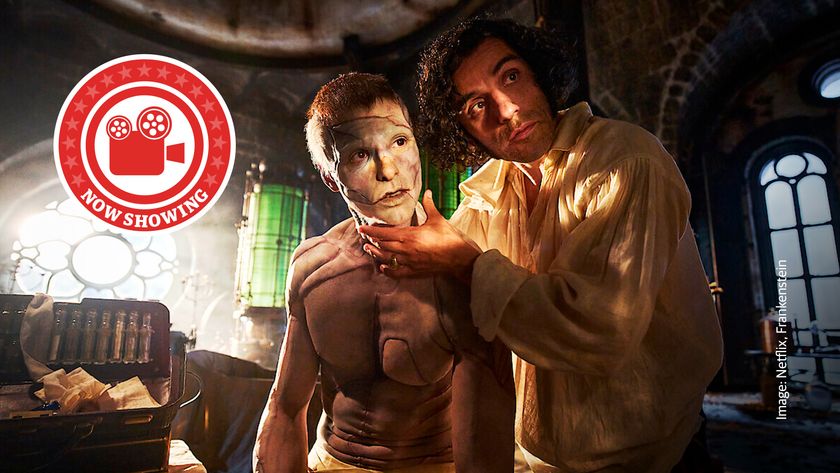 A still image taken from Guillermo Del Toro&#039;s Frankenstein. Frankenstein holds the creature&#039;s head gently towards the light, with a stained glass window behind them.