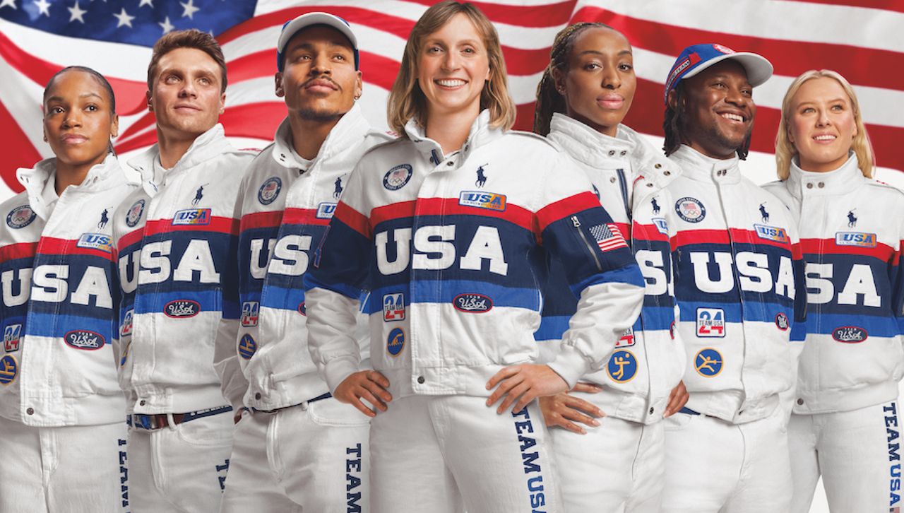 members of team USA wear their closing ceremony uniforms for the 2024 olympics including a ralph lauren racing jacket while standing in front of the american flag